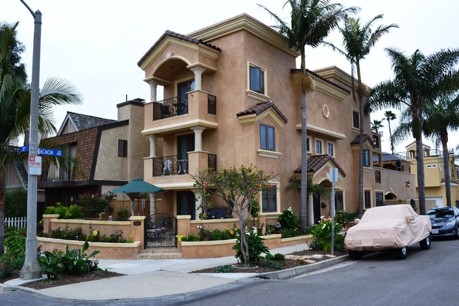 Existing three-story house, corner view with stacked balconies